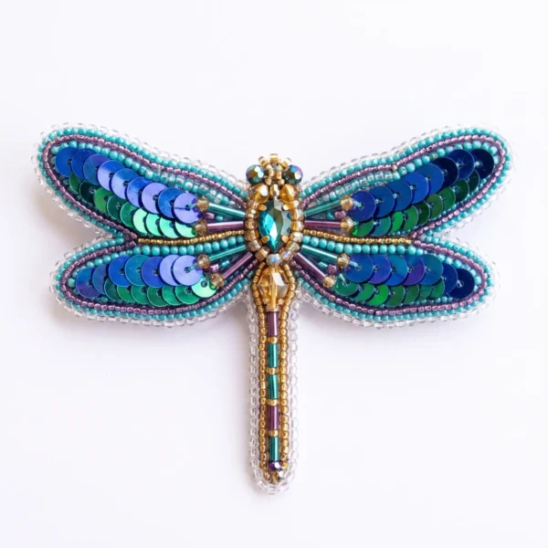 Blue Dragonfly Hand Beaded Brooch Blue dragonfly hand beaded brooch with turquoise seed beads, blue and green sequins, metallic bugle beads and faceted crystal embellishments.