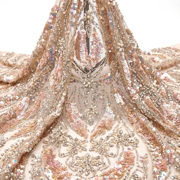 Blush Sequin Floral Beaded Fabric Blush sequin beaded fabric with iridescent leaf motifs, crystal floral embroidery and pearl embellishments on sheer mesh.