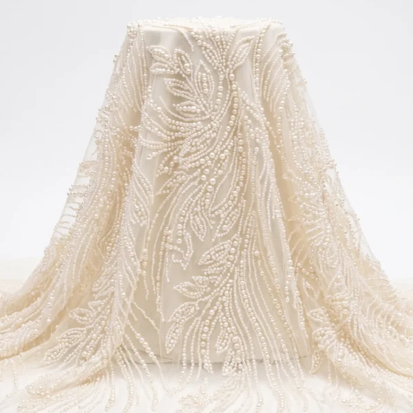 Botanical Pearl Beaded Fabric Ivory pearl beaded fabric with flowing botanical leaf embroidery handcrafted on sheer mesh for bridal gowns and couture dresses.