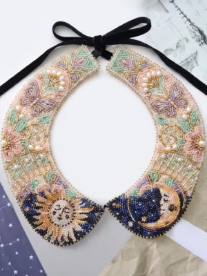 Celestial Floral Hand Beaded Collar Hand beaded detachable collar with sun, moon, butterfly and floral motifs in pastel, navy blue, gold and pearl beadwork.