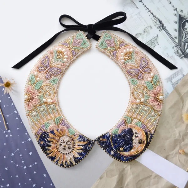 Hand beaded detachable collar with sun, moon, butterfly and floral motifs in pastel, navy blue, gold and pearl beadwork.
