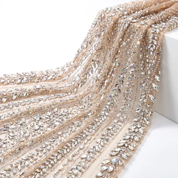 Champagne Leaf Crystal Beaded Fabric Champagne crystal beaded fabric with cascading leaf motifs, clear faceted stones and intricate hand embellished detailing.