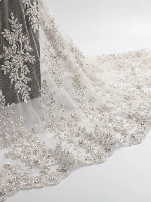 Ivory Crystal Hand Beaded Floral Lace Fabric Ivory crystal hand beaded lace fabric with floral embroidery and scalloped embellished border.