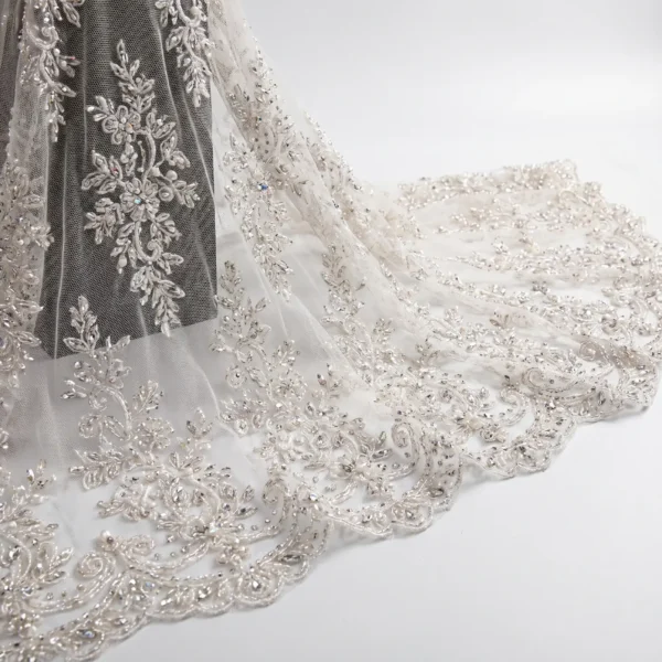 Ivory Crystal Hand Beaded Floral Lace Fabric Ivory crystal hand beaded lace fabric with floral embroidery and scalloped embellished border.