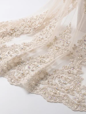 Ivory Pearl & Crystal Hand Beaded Lace Fabric Ivory pearl and crystal hand beaded lace fabric with ornate floral embroidery and scalloped border.