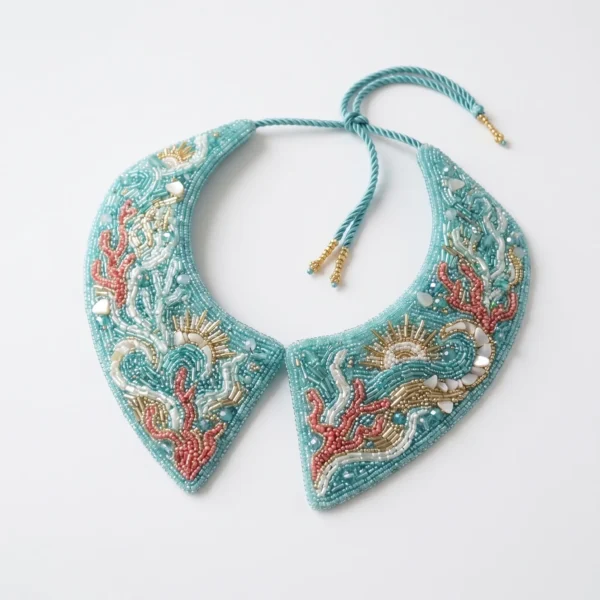 Aqua blue hand beaded collar with coral, wave, shell and sun motifs in pink, white and gold bead embroidery.