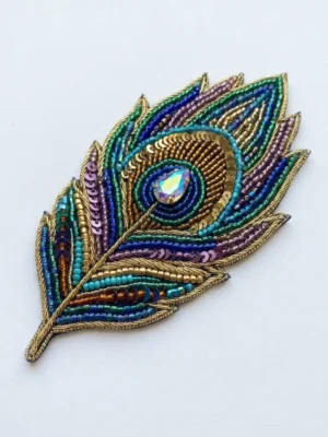 Peacock Feather Hand Beaded Patch Peacock feather beaded patch manufacturer & exporter for fashion brands and wholesalers. Custom hand beaded patches for OEM, private label and bulk orders.
