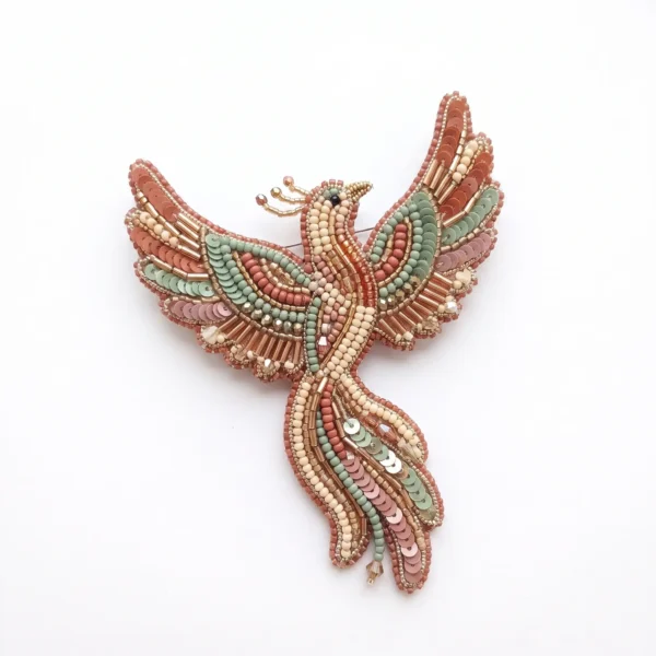 Phoenix bird hand beaded brooch with blush pink, sage green and ivory seed beads, sequins, metallic bugle beads and crystal accents.