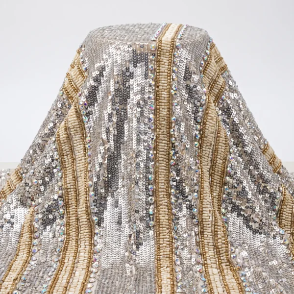 Silver Wave Sequin Beaded Fabric Silver sequin beaded fabric with flowing ivory bugle bead panels, gold bead outlines and iridescent crystal accents.