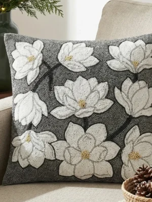 White floral hand beaded pillow with dimensional flower motifs on a dark beaded background
